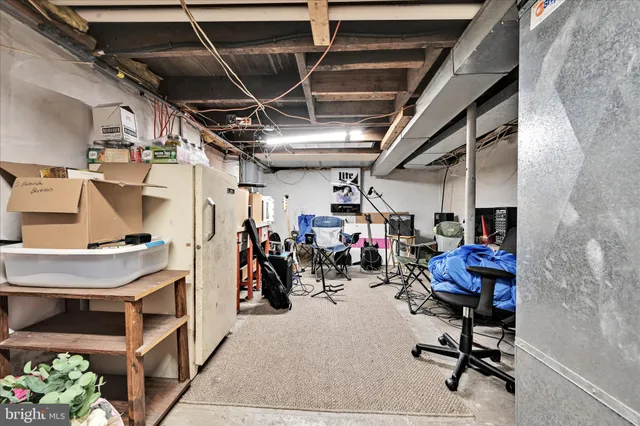 a view of a storage room with shelves fridge and stairs