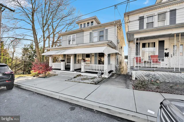 a view of a white house with large windows and a table and chairs