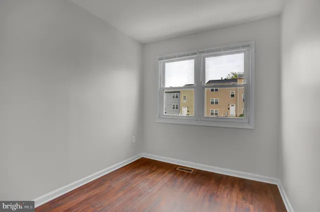 a view of a small space with wooden floor and a window