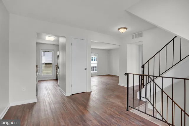 a view of empty room with wooden floor
