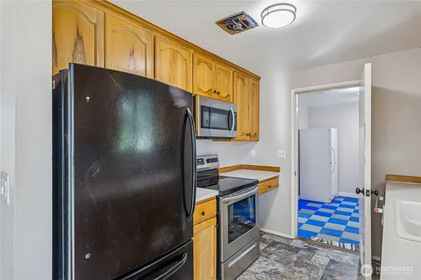 a kitchen with stainless steel appliances granite countertop a refrigerator and a sink