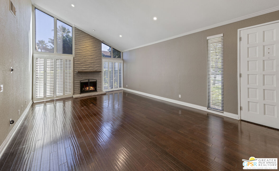 a view of empty room with wooden floor and fireplace