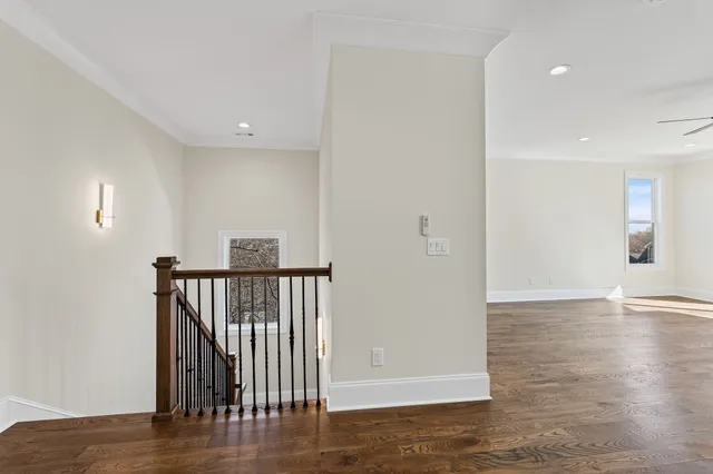 a view of an empty room with a window and wooden floor