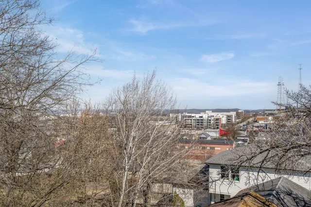 an empty room with wooden floor ceiling fan and windows