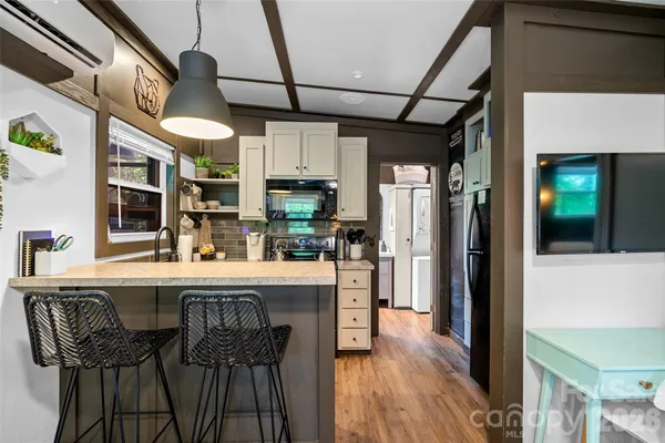 a kitchen with stainless steel appliances granite countertop a table chairs and a refrigerator
