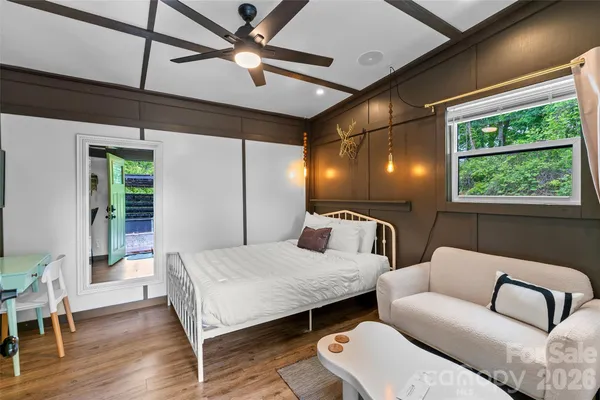 a bedroom with furniture and a large window