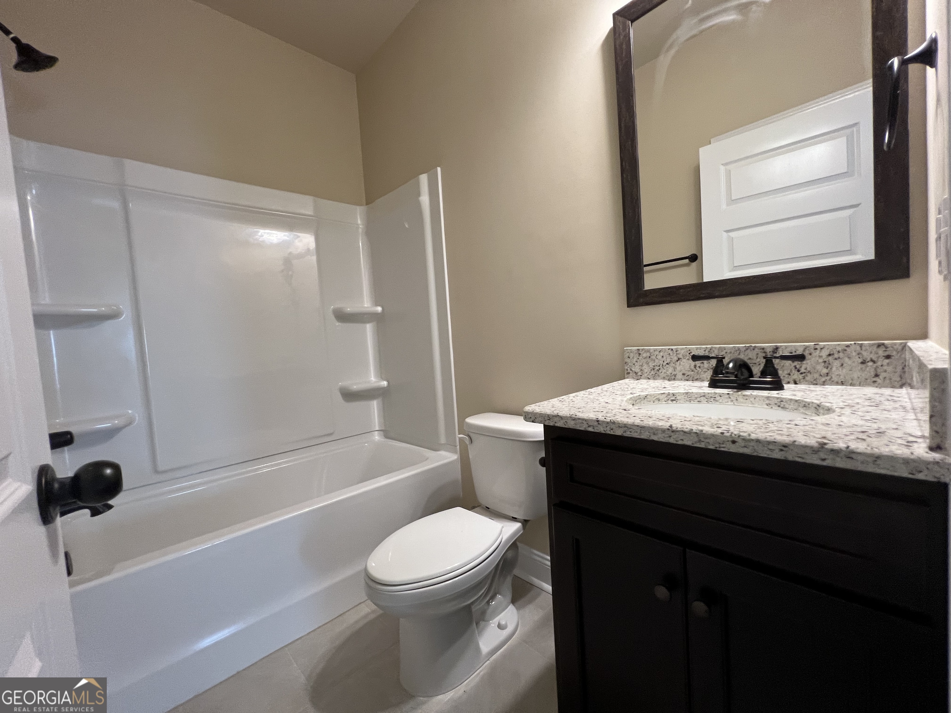341 Homestead Circle Forsyth, GA 31029 - Photo 15 of 38 a bathroom with a granite countertop sink toilet a mirror and shower
