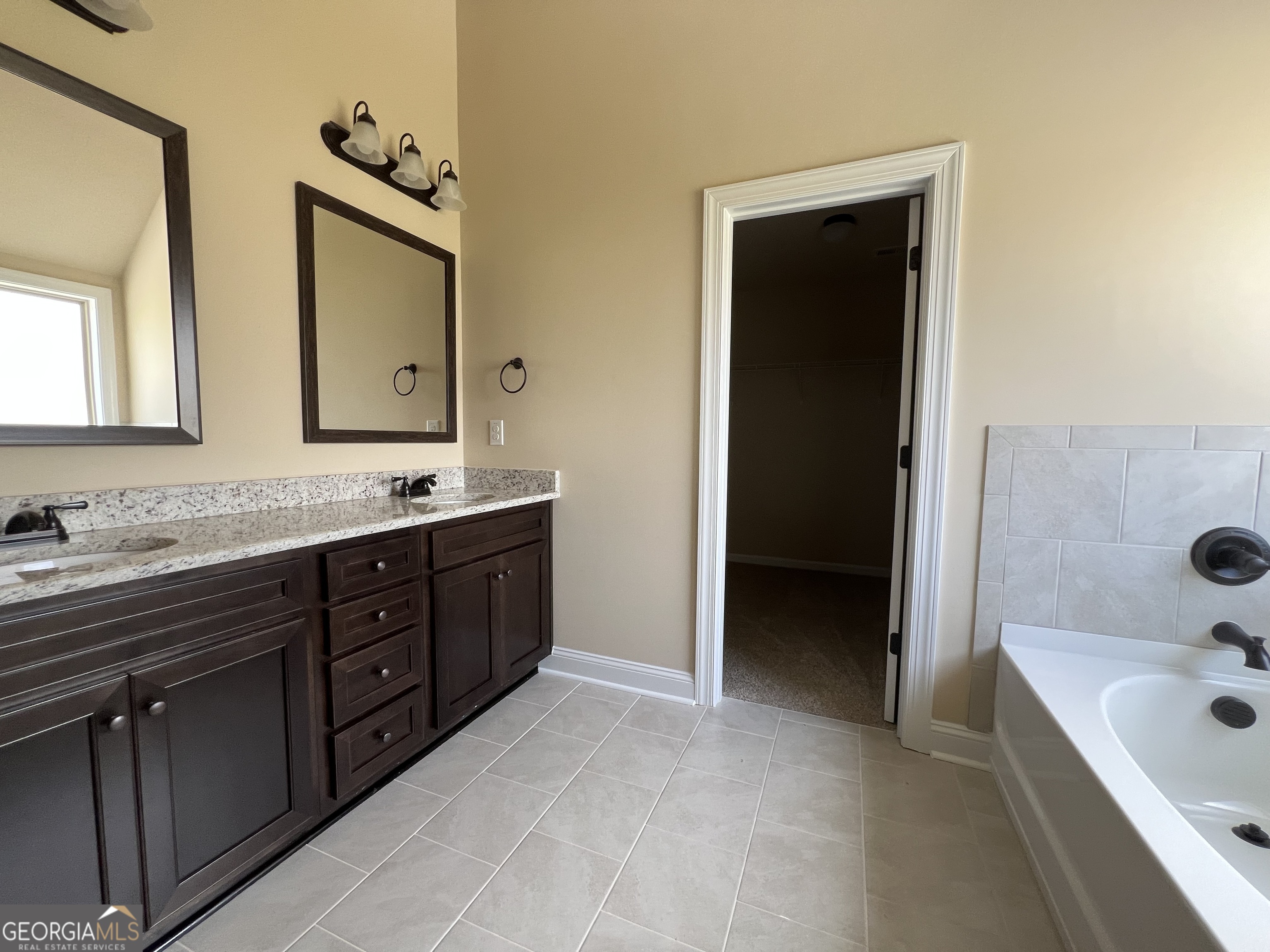 341 Homestead Circle Forsyth, GA 31029 - Photo 18 of 38 a spacious bathroom with a tub double sink and mirror