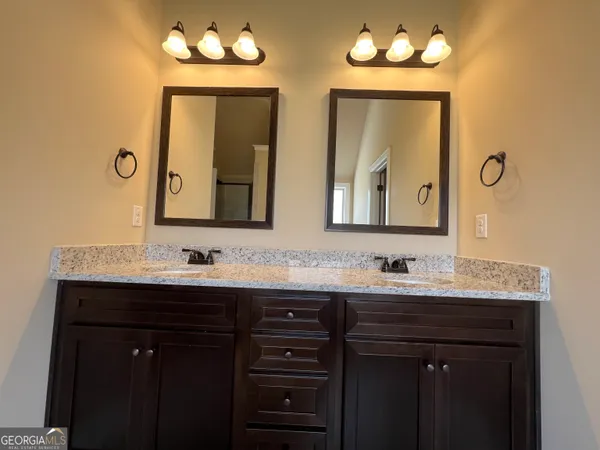 a bathroom with double vanity sinks and a mirror