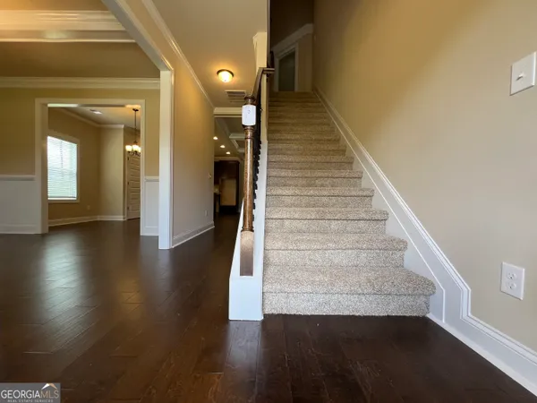 a view of a hallway with wooden floor and stairs