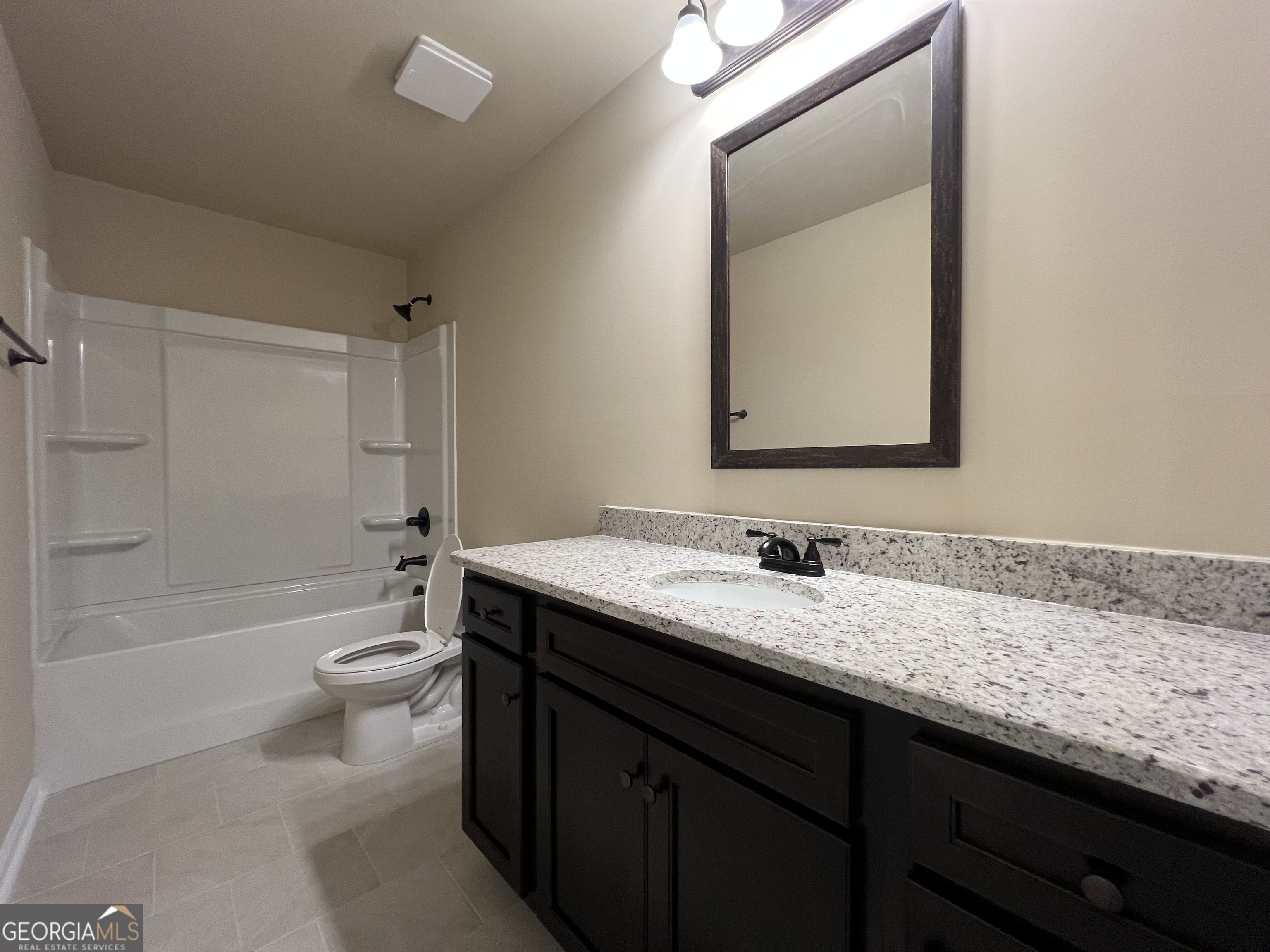 341 Homestead Circle Forsyth, GA 31029 - Photo 32 of 38 a bathroom with a granite countertop sink mirror vanity and toilet