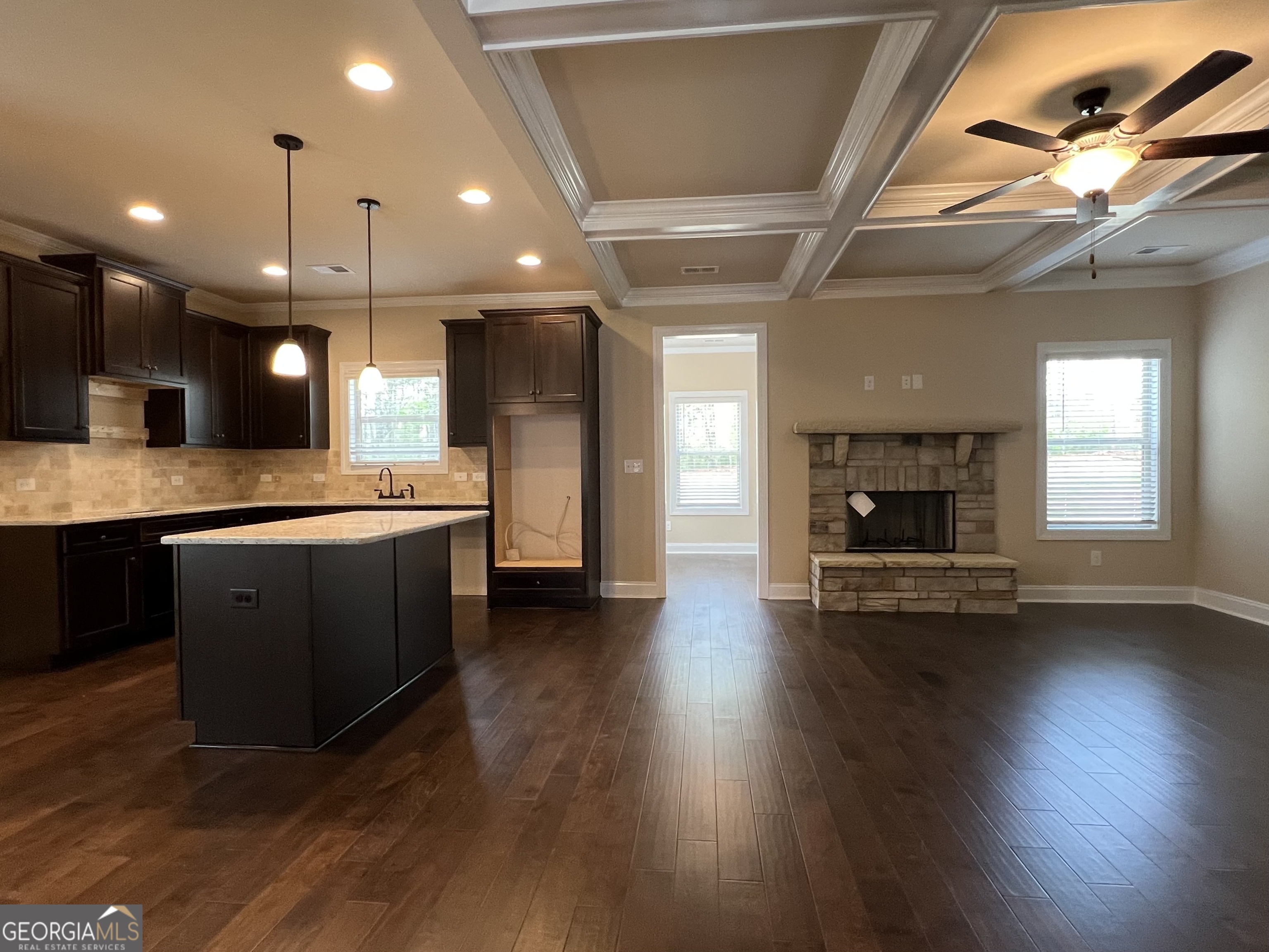 341 Homestead Circle Forsyth, GA 31029 - Photo 38 of 38 a large kitchen with stainless steel appliances kitchen island a large counter tops a stove a sink dishwasher and a fireplace with wooden floor