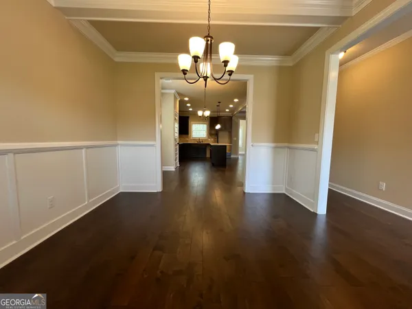 a hallway with wooden floor chandelier and livingroom view