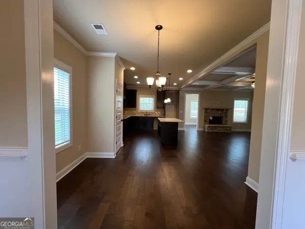 a view of a livingroom with furniture wooden floor and a kitchen