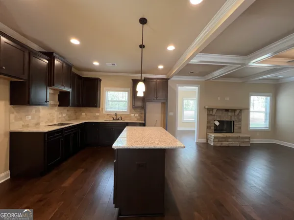 a large kitchen with stainless steel appliances granite countertop a sink dishwasher a stove and a large oven with wooden floor