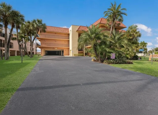 a front view of a house with a garden and trees