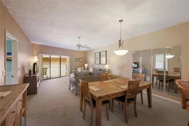 a view of a dining room and livingroom with furniture wooden floor a chandelier