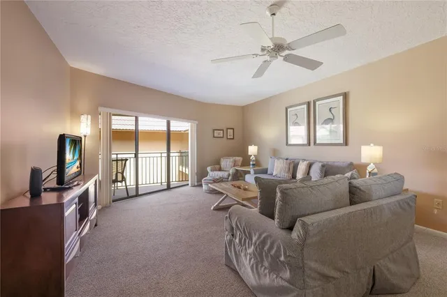 a living room with furniture floor to ceiling window and a flat screen tv