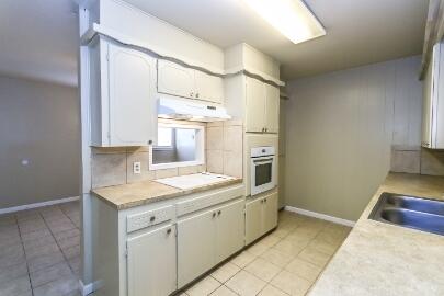 5408 31st Street Lubbock, TX 79407 - Photo 12 of 33 a kitchen with a sink stove and cabinets