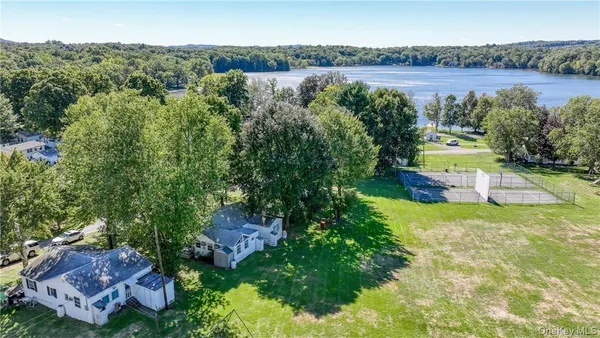 an aerial view of a house with a yard and lake view