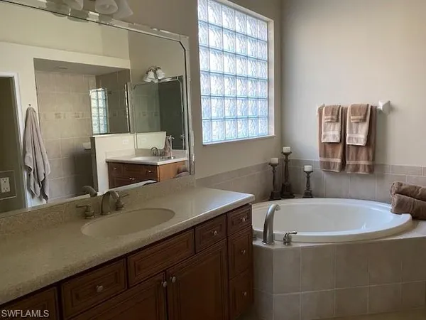 a bathroom with a tub sink and mirror