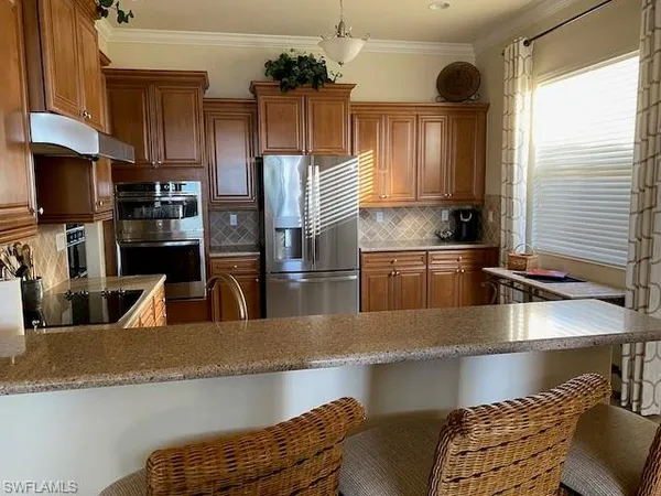 a kitchen with stainless steel appliances granite countertop a sink a stove and a refrigerator