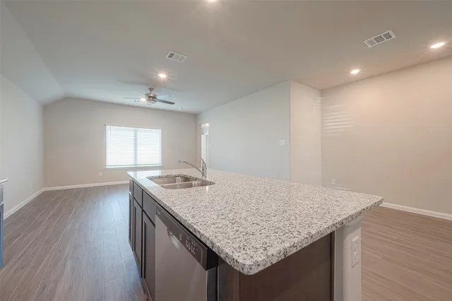 a kitchen with granite countertop sink and wooden floor