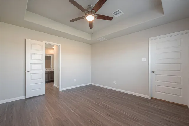 an empty room with closet and a ceiling fan