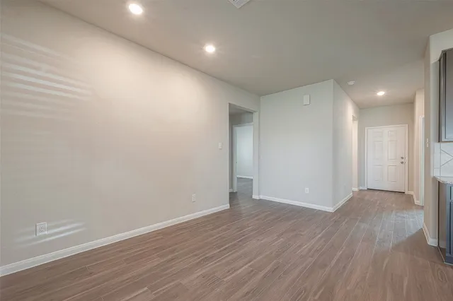 a view of an empty room with wooden floor