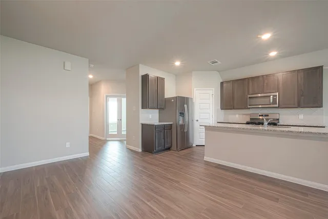 a kitchen with stainless steel appliances granite countertop a refrigerator and a stove top oven