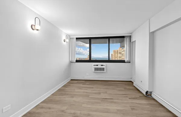 an empty room with wooden floor and a window