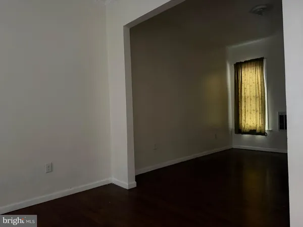 an empty room with wooden floor and a window