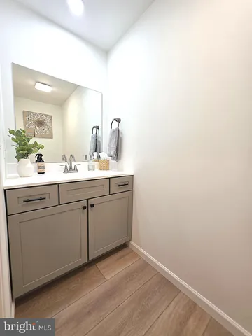 a room with a sink cabinets and a wooden floor
