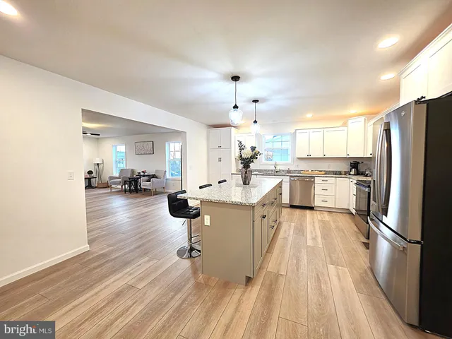 a kitchen with stainless steel appliances a refrigerator a stove a sink dishwasher and a oven with wooden floor