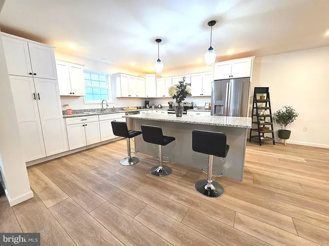 a view of a kitchen with kitchen island and stainless steel appliances