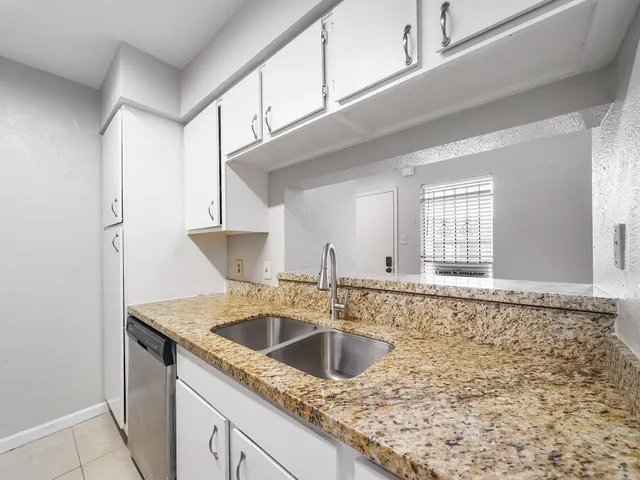a kitchen with granite countertop a sink and a stove