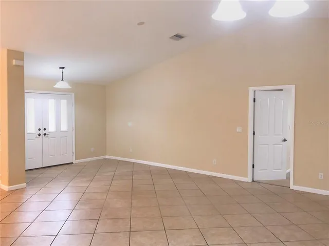 an empty room with white walls and windows