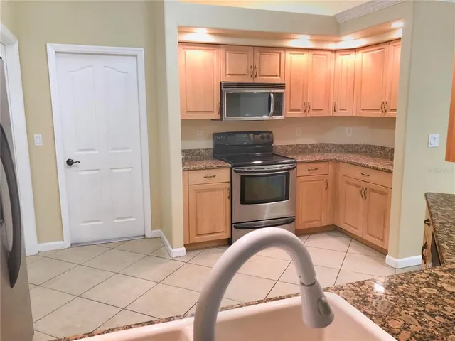 a kitchen with stainless steel appliances granite countertop a stove a sink and a microwave