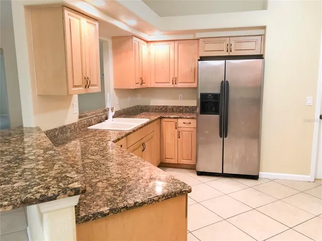 a kitchen with kitchen island sink refrigerator and cabinets