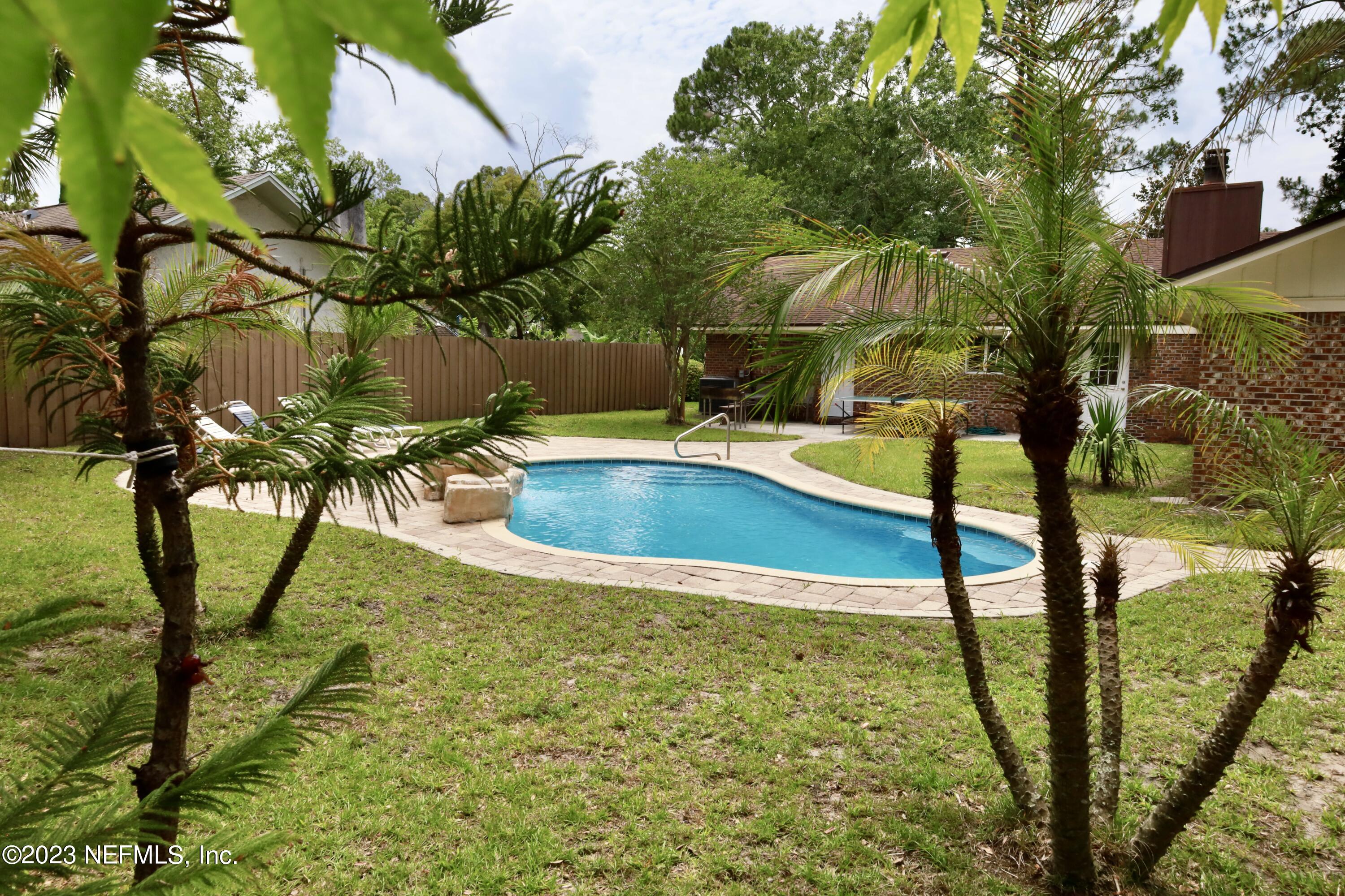 a view of swimming pool with a yard and sitting area