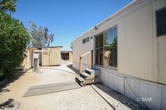 1313 North Leroy Street Ridgecrest, CA 93555 - Photo 26 of 27 a view of a white house with a small yard and wooden fence