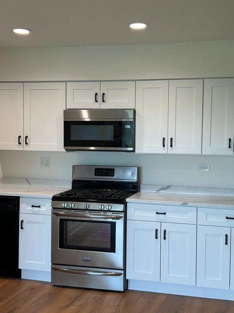 239 North Mill Road, Unit 403A Addison, IL 60101 - Photo 3 of 10 a kitchen with white cabinets and appliances