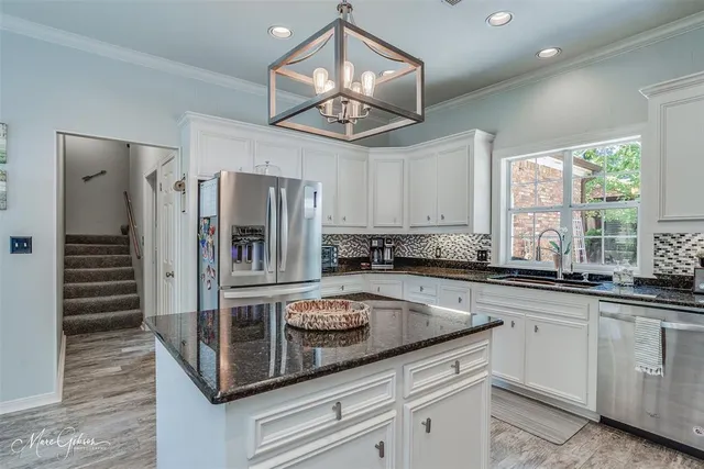 a kitchen with stainless steel appliances granite countertop a sink a stove and refrigerator
