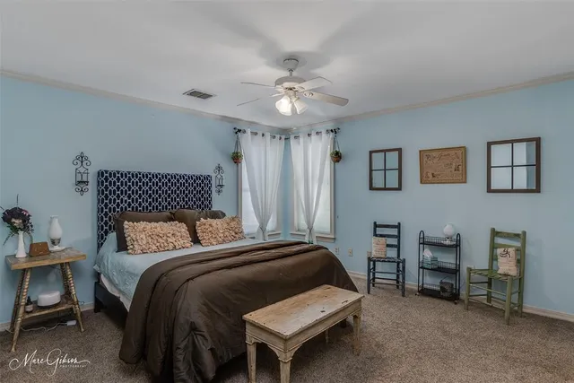 a bedroom with a bed a chair and a chandelier