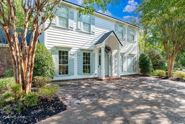 a view of a white house with a large windows and large trees