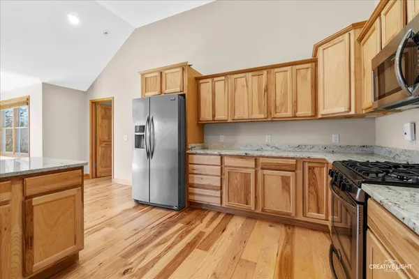 a kitchen with stainless steel appliances granite countertop a stove a sink and a refrigerator