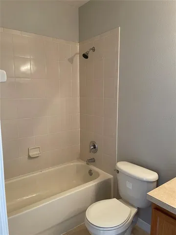 a white toilet and tub sitting next to a bathroom sink