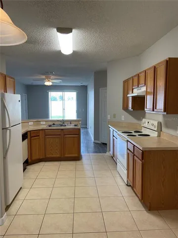a kitchen with stainless steel appliances granite countertop a stove a sink dishwasher and a refrigerator