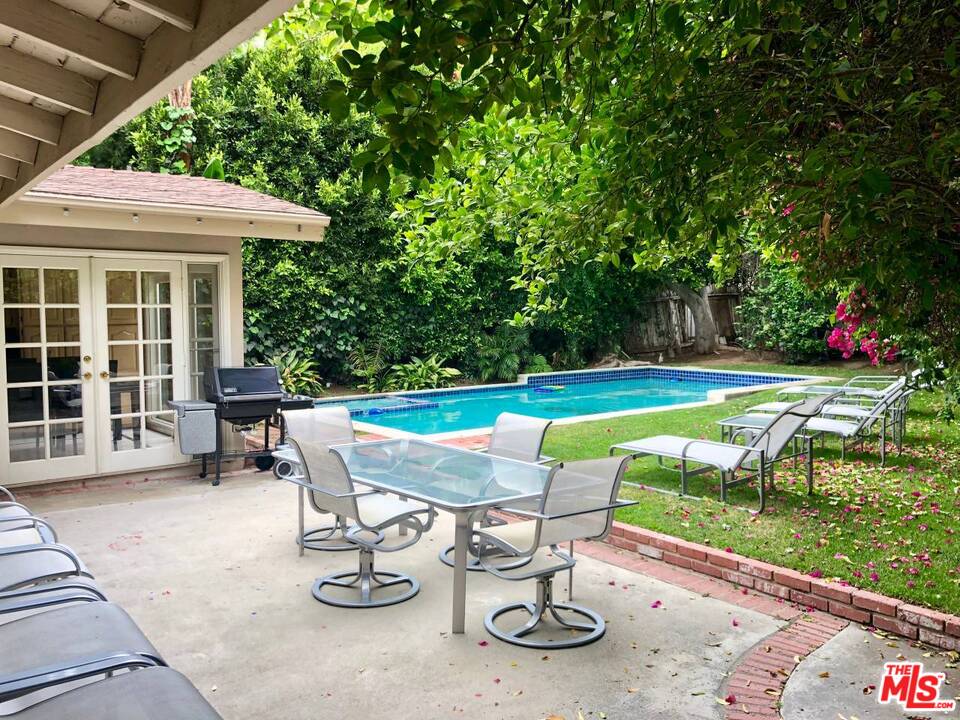 a view of a swimming pool with sitting area and garden