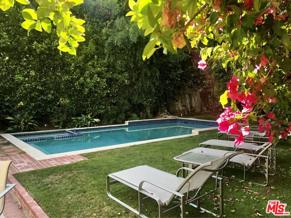 9601 Heather Road Beverly Hills, CA 90210 - Photo 11 of 21 a view of a wooden floor and swimming pool in the back yard